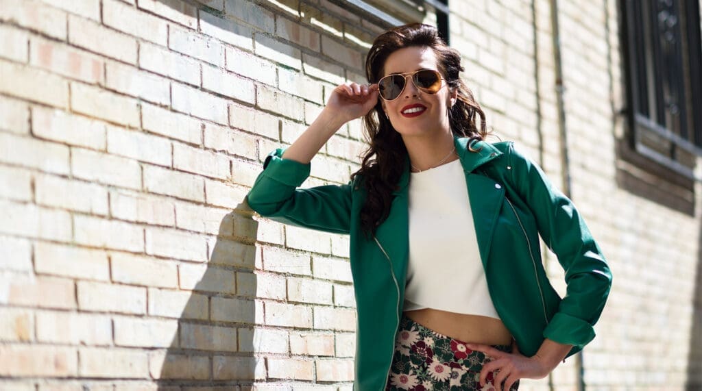 Young brunette woman with black coatings sunglasses in urban background